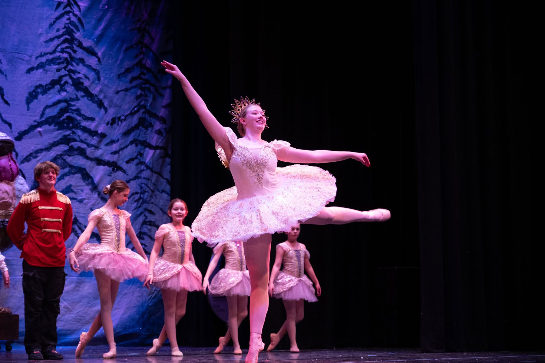 A Weehawken ballerina performing on pointe with dancers behind her.